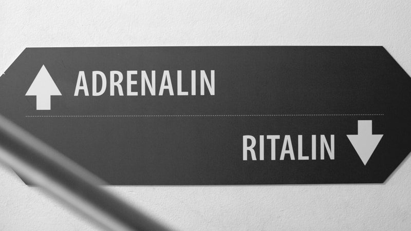 Ein Wegweiser mit zwei Pfeilen: nach oben Adrenalin, nach unten Ritalin